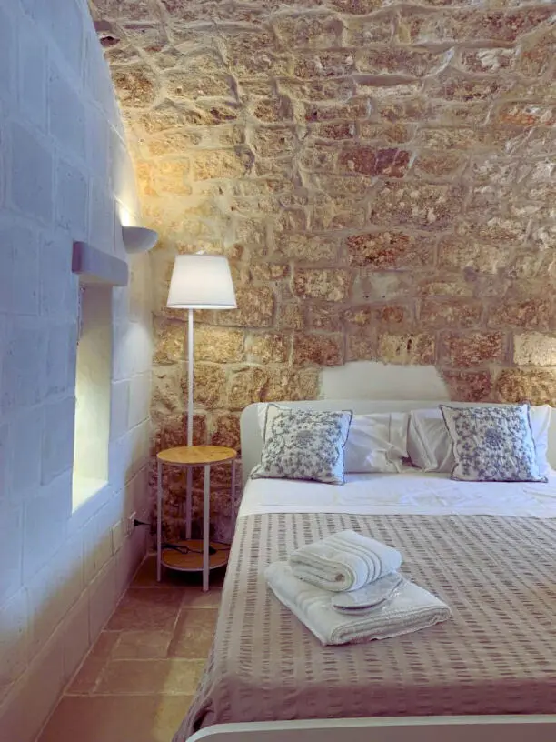 Camera con volta in pietra e arredi in stile minimal al B&B Atagio nel centro storico di Ostuni, con letto matrimoniale e luce naturale