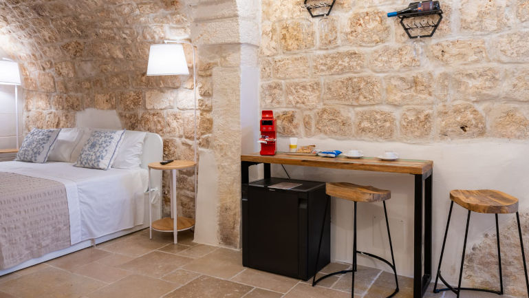 Accogliente suite di Atagio nel centro storico di Ostuni con vista sulle antiche vie cittadine, dotata di tutti i comfort, tra cui parcheggio riservato, Wi-Fi gratuito e benvenuto con vino e delizie locali.