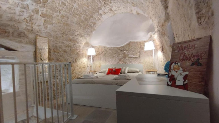 Camera di Cà Giò nel centro storico di Ostuni con vista sulle antiche stradine, dotata di comfort moderni come Wi-Fi gratuito, parcheggio riservato, e benvenuto con vino o dolci locali.